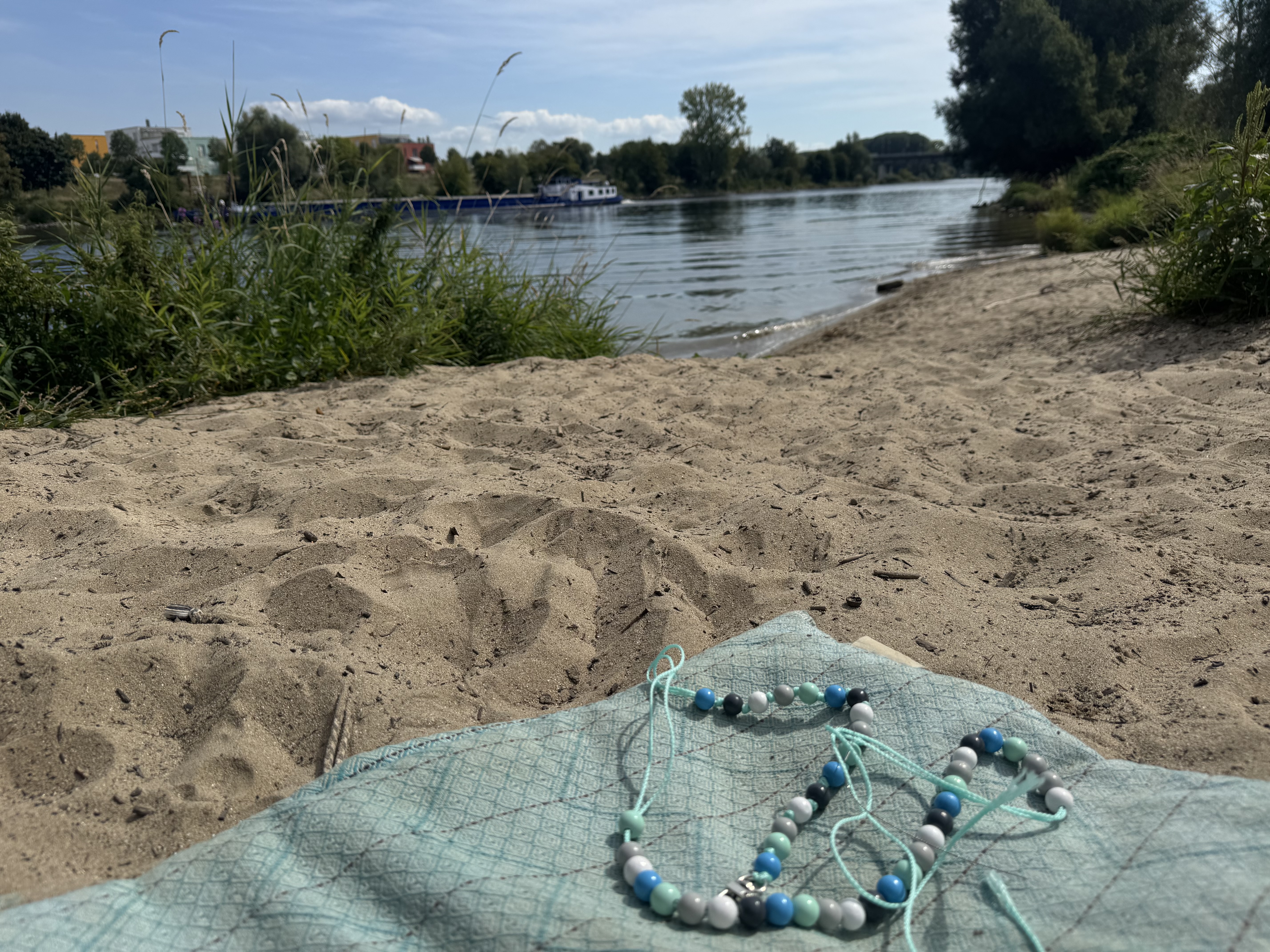 Marion Fischer bastelt am Ufer der Donau mit den Holzperlen von Murmelkiste